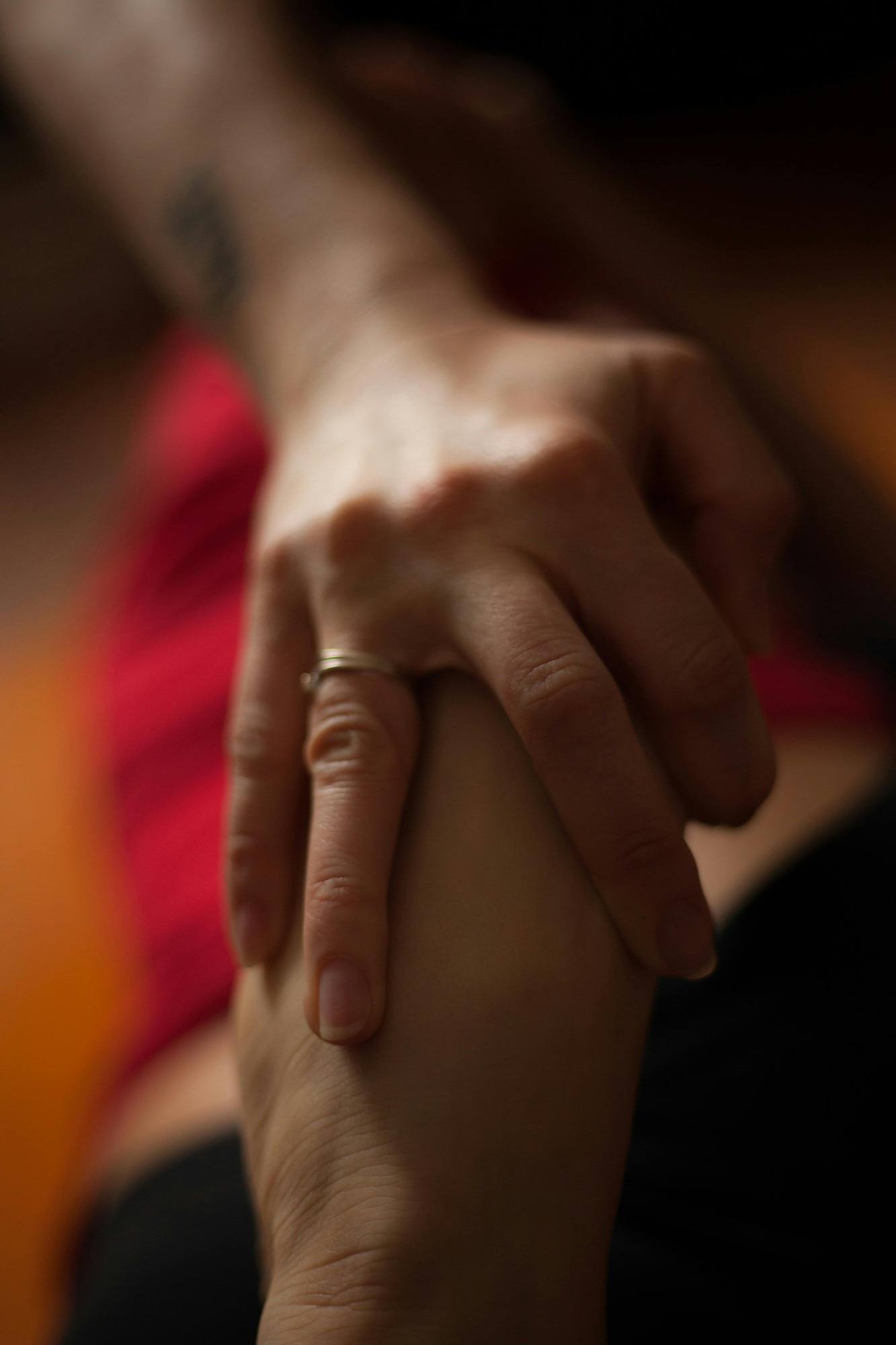 A person gently holds the hand of another, symbolizing support and connection between them.
